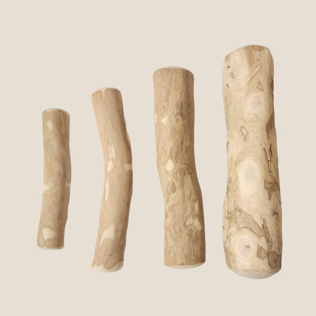 Four wooden sticks of varying lengths on a beige background.