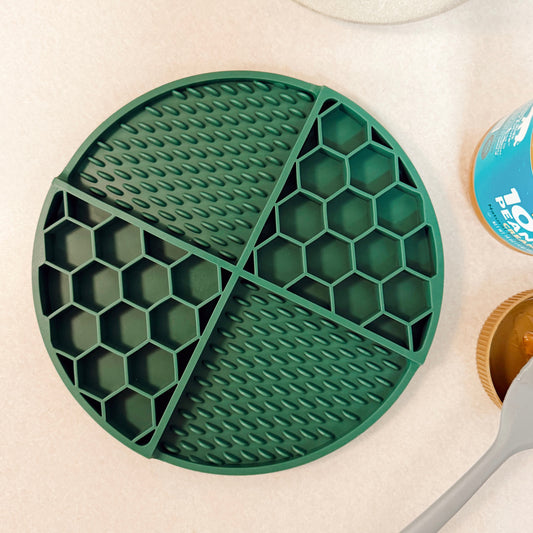 Green silicone dog lick mat with honeycomb pattern on a kitchen counter.