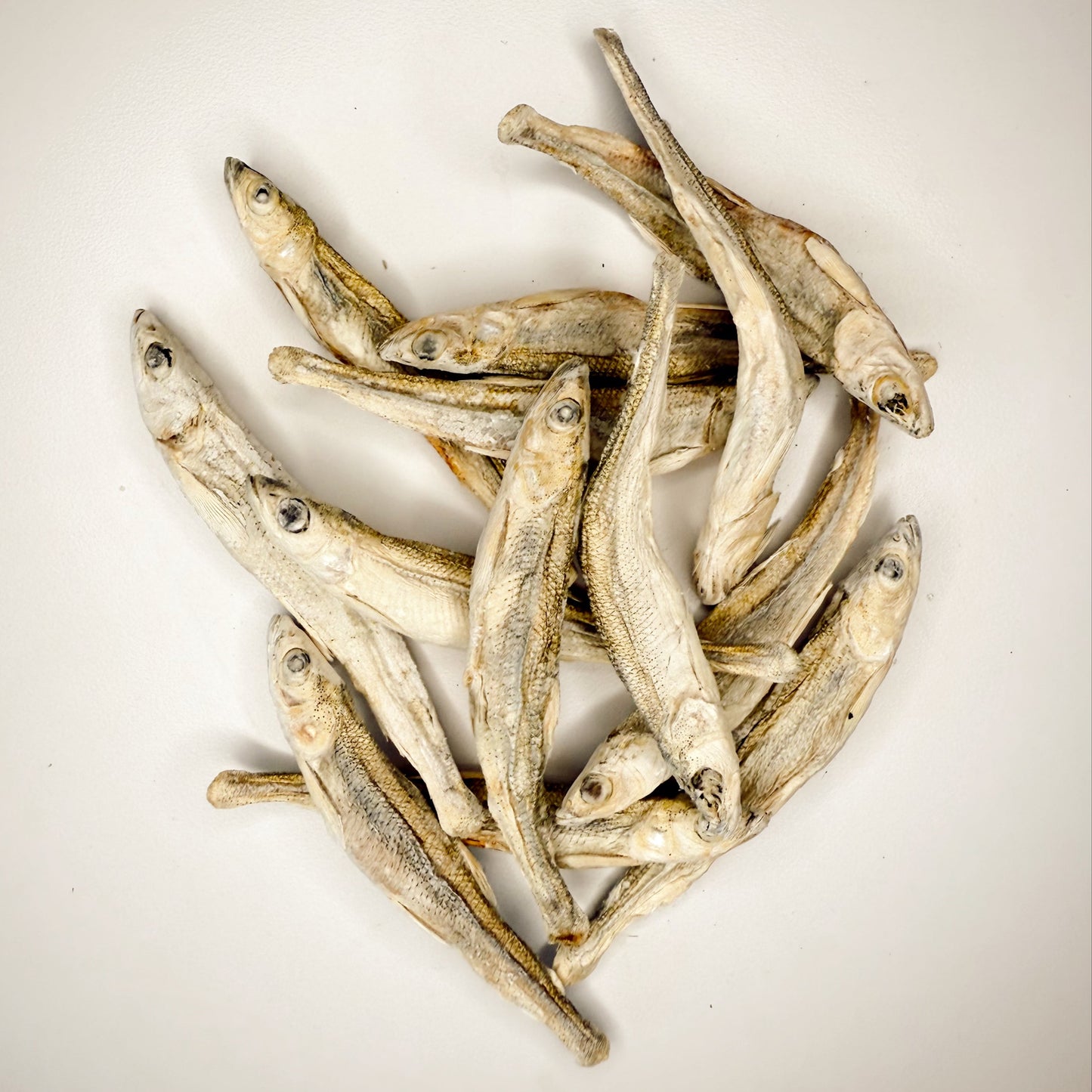 Dried fish on a beige background.