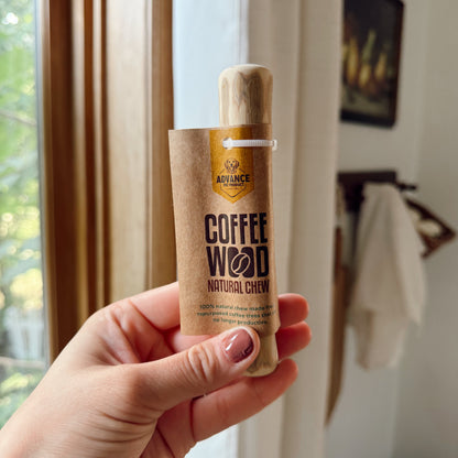 Hand holding a 'Coffee Wood' product with a window in the background