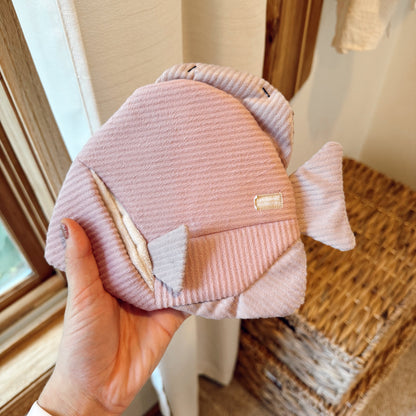 Hand holding angel fish dog toy indoors.